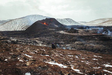 Tourist is watching the eruption of the volcano in Iceland, April 2021
