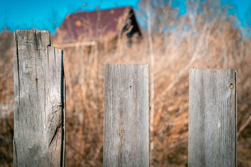 An old fence and a small house in the background.