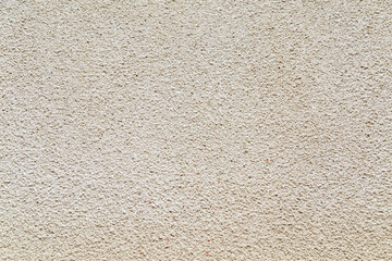 Decorative plaster of beige color with small pimples, wall surface. Overlay texture for interior or exterior design. Decorative render. Single-ply monolithic plaster decorative background and sample