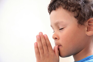 boy praying to God with hands together on white background stock photo