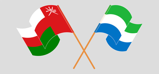 Crossed and waving flags of Oman and Sierra Leone