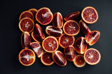 sicilian orange cut into pieces.
citrus, vitamins, on a dark background. wooden board. Healthy Eating.
food for rest. vegetarianism