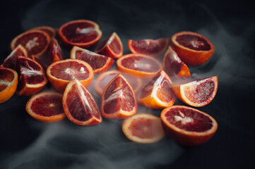 sicilian orange cut into pieces.
citrus, vitamins, on a dark background. wooden board. Healthy...