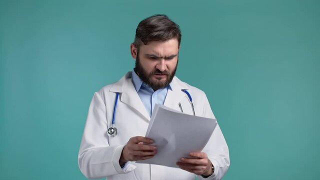 Angry Doctor Throws Away Papers. Furious Male Doc Man Throwing Crumpled Paper, Having Nervous Breakdown At Work, Screaming In Anger, Stress Concept. Blue Studio Background