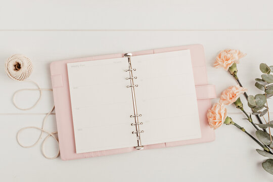 Open planner and flowers. Workspace with notebook. Freelance business, organization, wedding planning