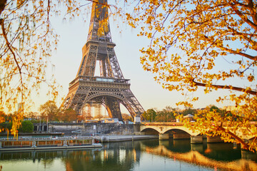 Obraz premium Scenic view of the Eiffel tower and tree branches with first leaves at early morning