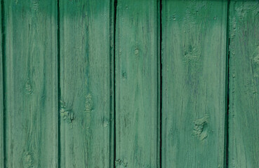 Old, cracked wood planks, painted a light green that had faded in the sun.