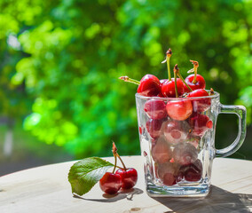 Fresh cherries in glass containers on a summer day