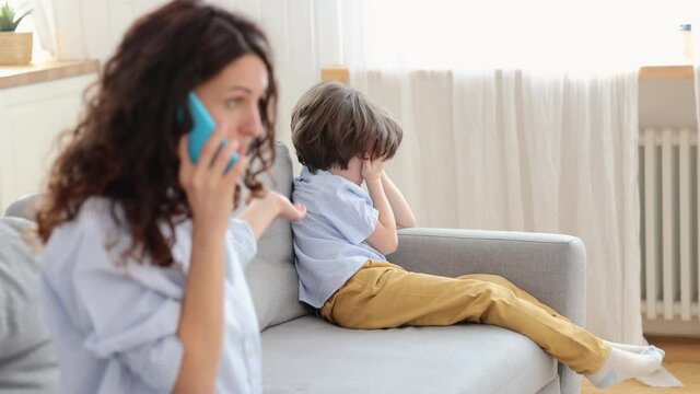 Little boy cry while mom quarrel with dad on phone call. Depressed son tired of family fights. Angry woman scream on ex husband on mobile for not spending time with kid. Parents problem and conflict