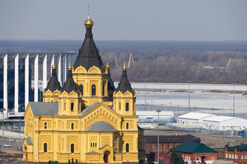 Beautiful Orthodox church made of yellow brick on the river bank. Alexander Nevsky Cathedral on in Nizhny Novgorod, Russia. High