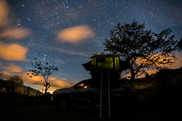 Car with roof top tent under a starry sky, overland