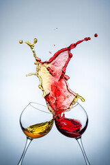 Red and white wine spills out of the glasses