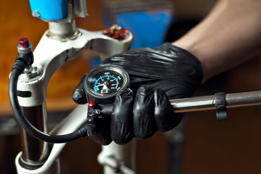 The master inflated the bicycle frame. Pump and male hands close up.