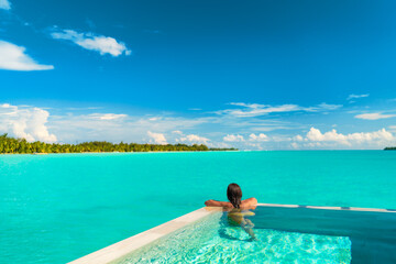 Luxury swimming pool spa resort travel honeymoon destination woman relaxing in infinity pool at...