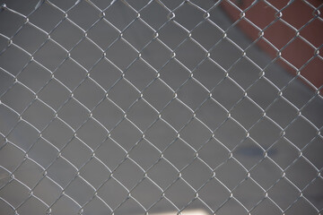 Full frame partial close-up view of a chainlink fence with inserted gray blinder strips