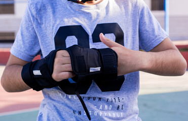 A preteen puts on hand guards to skate.