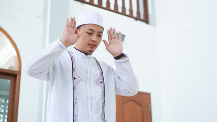 Fototapeta premium A portrait of an asian muslim man pray at mosque, the pray name is sholat, takbiratul ihram