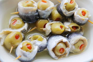 Anchovies with olives on the wooden table, appetizer