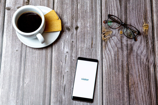 04-13-2021 Portsmouth, hampshire, UK A Mobile phone or cell phone laid on a wooden table showing the viator app on screen