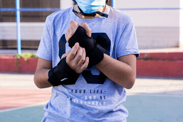 A preteen puts on hand guards to skate.