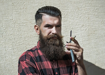 Young man hipster hairdresser. Barber scissors and straight razor, barber shop, suit. Vintage barber shop, shaving. Portrait bearded man. Vintage barbershop.