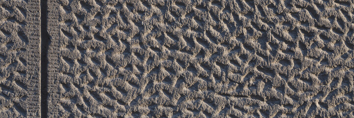 Wall with decorative imitation of stone blocks. Rough surface, painted in brown color. Wide panoramic texture for background and design.