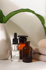 Home spa, cosmetic oil in a bottle, wooden bowl on a white table - 427755056