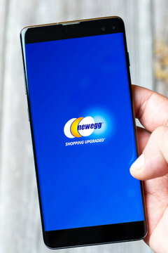 04-13-2021 Portsmouth, Hampshire, UK A Mobile phone or Cell phone being held in a hand showing the newegg shopping app on screen