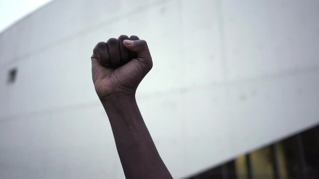 Raised African-American Fist In Protest Against Racism - Clenched Fist Of A Man Showing Support At Protest Of Black Lives Matter (BLM). - close up