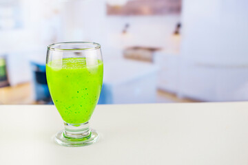 Glass of juice with cucumber and parsley on white table, Detox cocktail of raw fruits and vegetables and lettuce and parsley, the background is out of focus