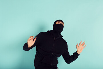 Thief with balaclava was spotted trying to steal in a apartment. Scared expression - obrazy, fototapety, plakaty