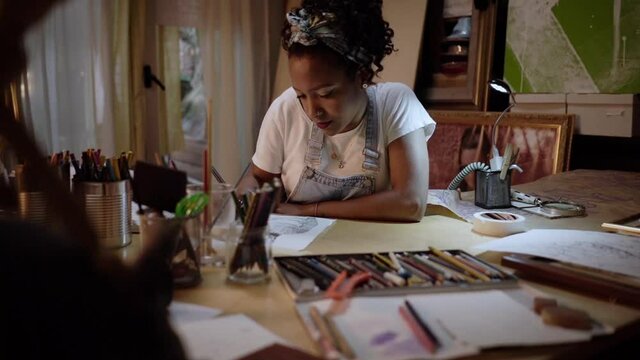 Young creative woman artist painting picture on canvas in art studio. Slow motion