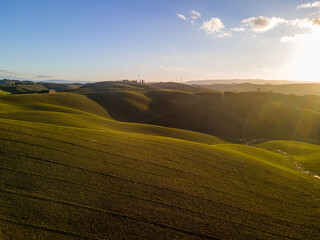 Fototapeta na wymiar Rolling hills at sunset in the countryside near Siena. Drone shot, aerial view