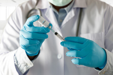 COVID-19 Vaccination, doctor holds syringe and bottle corona virus treatment vaccine