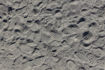 A beach sand background with multiple footprints