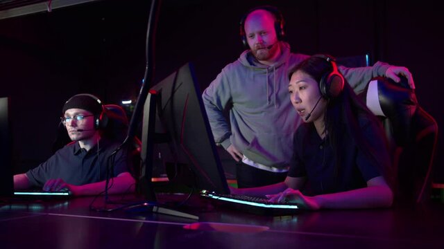 Individual training sessions with an esports coach in a computer club, an asian girl plays strategy