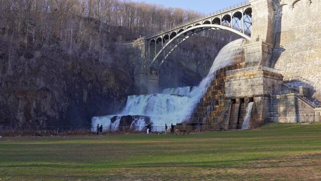 Visitors at meadow near waterfall of New Croton dam in Westchester County, New York