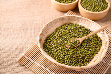 Mung bean seeds in wooden spoon and bamboo basket, Food ingredients in Asian cuisine and produce mung bean sprout
