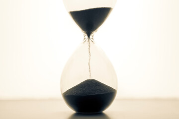 Hourglass on a light background. Time is money. Business solutions in time.