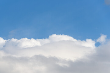 Blue sky with white clouds on a spring day as a nature background
