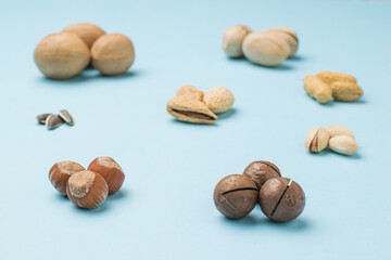 Stacked round sets of different nuts on a blue background.