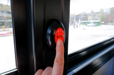 Hand pushing a bus stop bell button