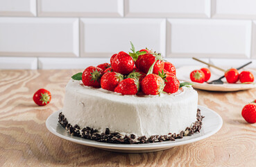 Whole chocolate cake with strawberry over wooden rustic background.