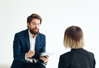 A man with documents in a suit and a woman for a job interview