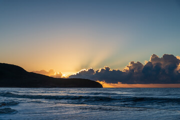 Sunrise at the seaside with low cloud bank