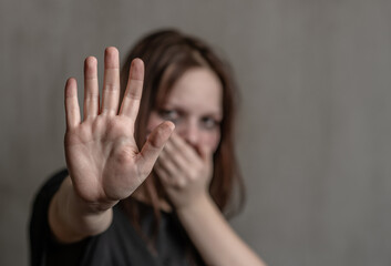 Crying teenage girl showing a stop sign with her hand