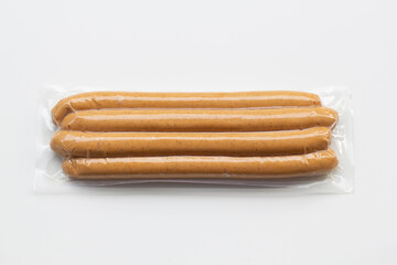Top view of fresh uncured pork frankfurter sausages packaged in vacuum plastic pack isolated on a...