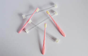 Pink superfine Japanese style plastic toothbrushes and its tubes in gray background