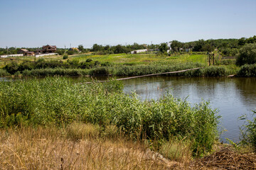 Long suspension bridge over the river in the village