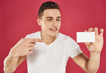 A guy with a business card in his hand gestures and emotions red background